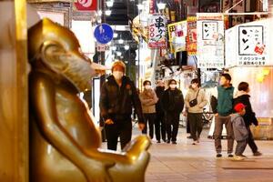 　大阪・新世界を歩く人たち。府は「まん延防止等重点措置」の適用を政府に要請した＝２１日夕