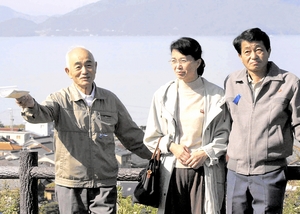 帰国したばかりの地村さん夫妻と、小浜湾を望む展望台を訪れた浜本雄幸さん（左）＝2002年10月24日、福井県小浜市