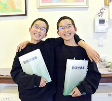 防災士の試験に合格し、双子で県内最年少となった泰佑さん（写真左）と友佑さん＝福井県坂井市内