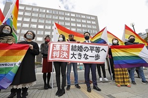 同性婚訴訟の札幌地裁判決後、「違憲判決」と書かれた紙を掲げる原告の弁護士と支援者ら＝３月１７日午前１１時３４分、北海道札幌市