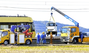 えちぜん鉄道の車両（左）と衝突し、線路から引き上げられる軽トラック＝１１月１５日午後１時２５分ごろ、福井県福井市中角町