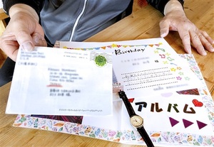 男性が受け取った亡き母親の遺品。孫からのバースデーカードの封筒（左）は閉じられたままだ＝福井県坂井市内