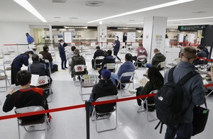 国際線で成田空港に到着した人たち。政府は新型コロナウイルスの新たな変異株「オミクロン株」の急拡大を受けた水際対策の強化措置として、全世界を対象に外国人の入国を禁止すると発表した＝11月29日午後、東京